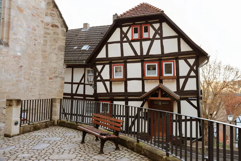 Handwerker saniert das Holzgerüst eines Fachwerkhauses mit Werkzeug und Holzbalken